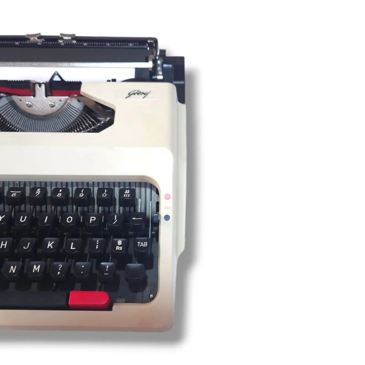 Godrej Prima Traveller typewriter close-up showing Godrej logo, black English keys and beige portable body