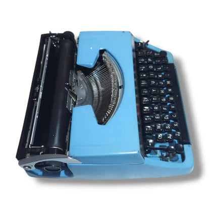 Top side view of blue Brother Charger 11 typewriter showing carriage, typebars and English manual typing keyboard