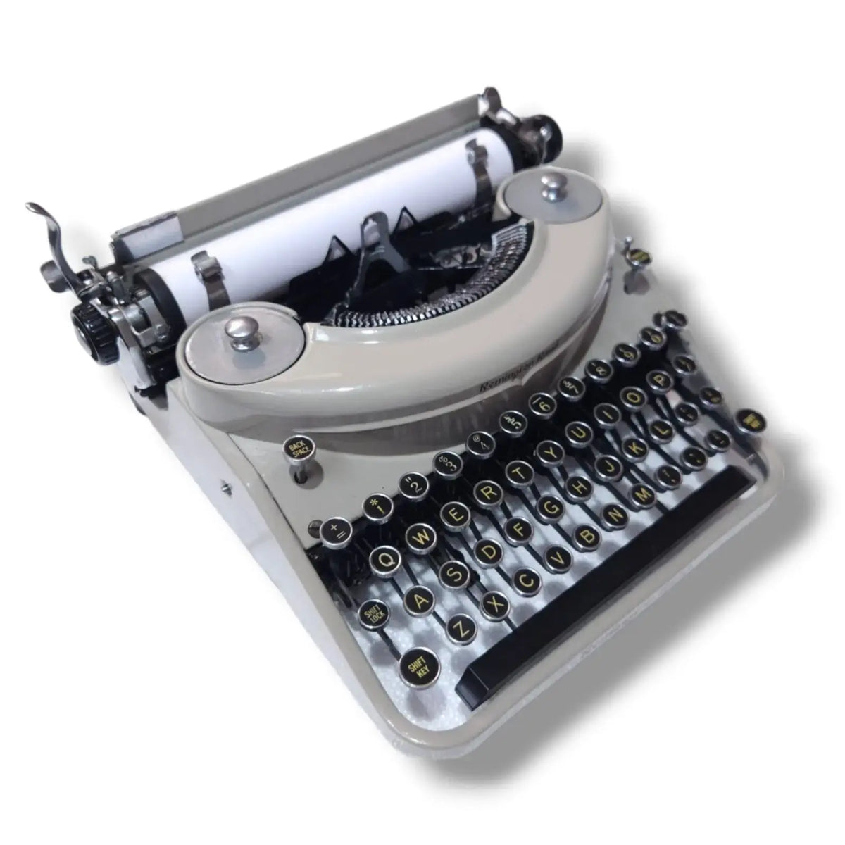 Remington Rand Noiseless typewriter angled view showing cream finish, round keys and vintage manual typing machine build