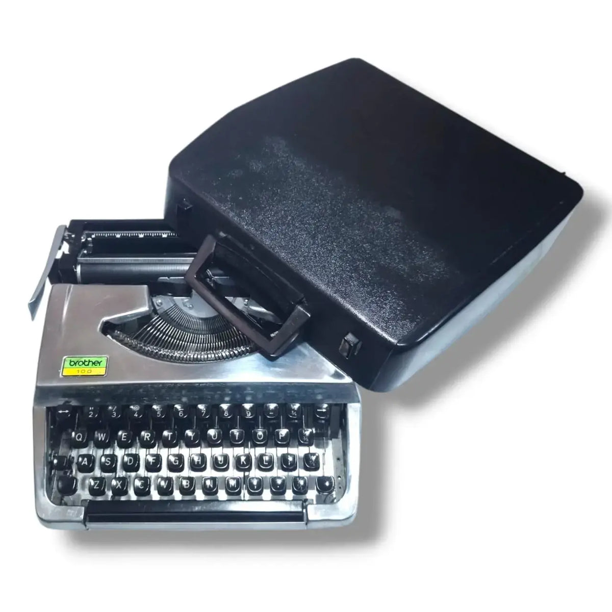 Brother 100 Deluxe chrome typewriter with black carry case, portable English typing machine for writers and collectors