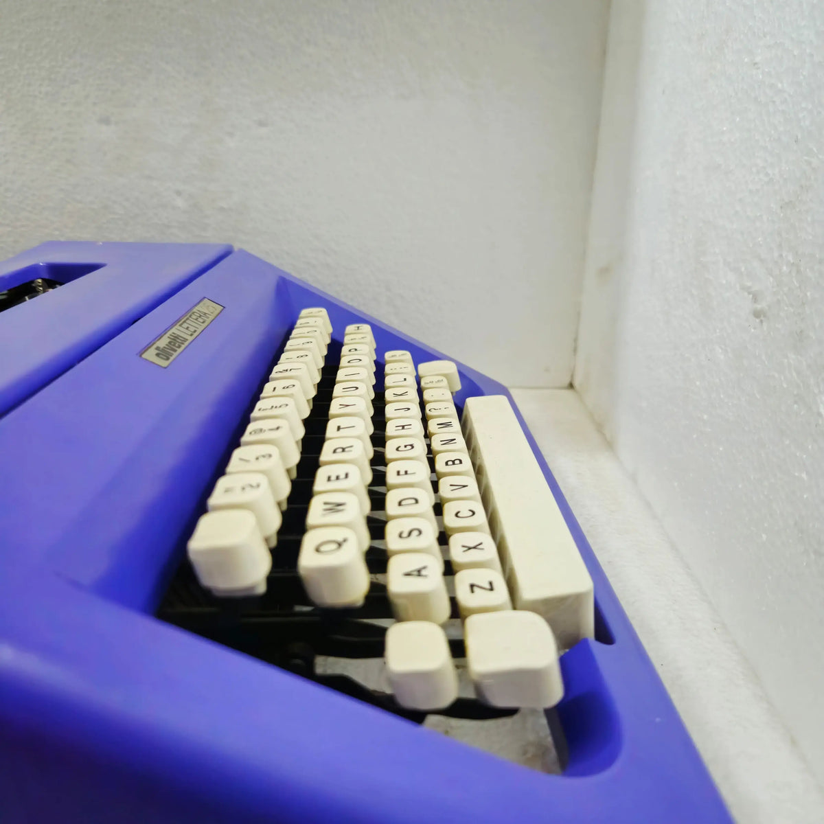 Stylish left-lower angle of white keytops on Carbon Purple Olivetti Lettera 25 Portable Typewriter