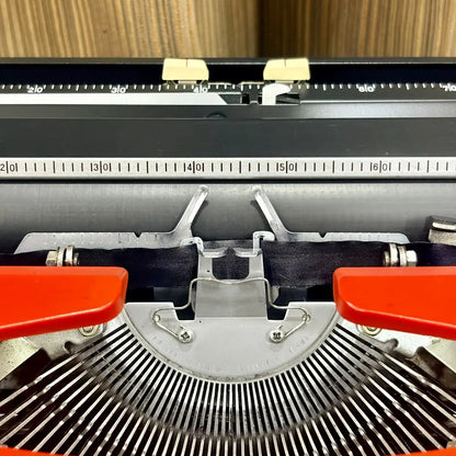 Brother Young Elite 513 portable typewriter side angle, scarlet red body, black keyboard and vintage mechanical construction | RR Typewriter Mart