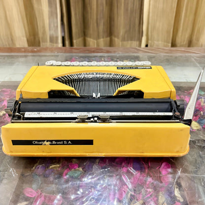 Rear view of yellow Olivetti Lettera 82 portable manual typewriter, showing Brazilian Olivetti do Brasil S.A. maker plate and carriage, RR Typewriter Mart