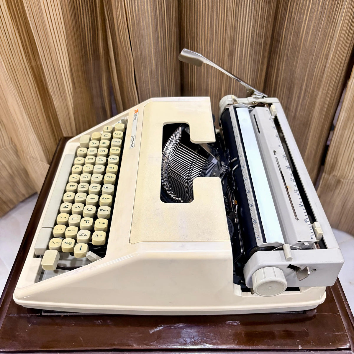 Royal Junior semi portable typewriter angled view showing cream body, carriage and case, from RR Typewriter Mart.
