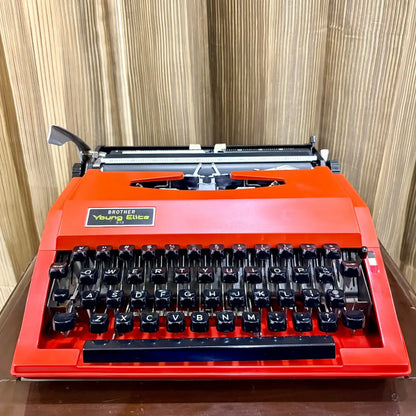 Brother Young Elite 513 vintage red typewriter in carrying case, showcasing the platen, carriage and manual typing mechanism | RR Typewriter Mart