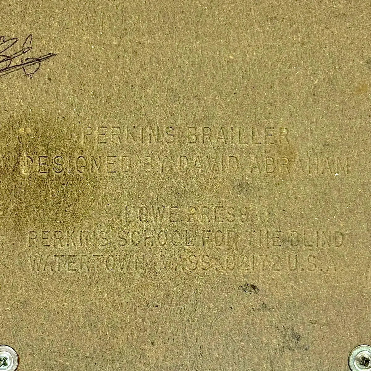 Close-up of Perkins Brailler plaque with embossed details, showing the Perkins Braille Typewriter from RR Typewriter Mart.