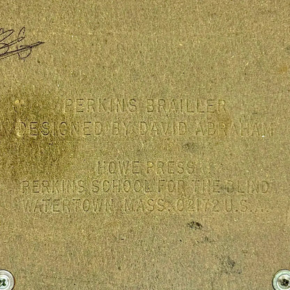 Close-up of Perkins Brailler plaque with embossed details, showing the Perkins Braille Typewriter from RR Typewriter Mart.