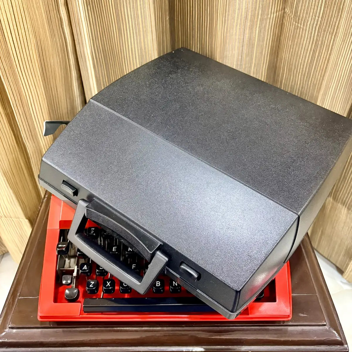 Brother Young Elite 513 red vintage typewriter viewed from rear, showing original case and mechanical carriage assembly | RR Typewriter Mart