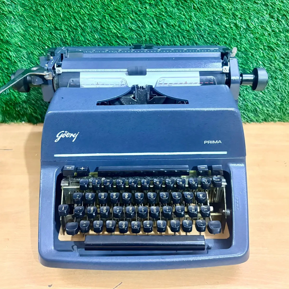 Godrej Prima Foolscap Punjabi Typewriter in blue, front profile showing Gurmukhi keyboard and mechanical typing carriage