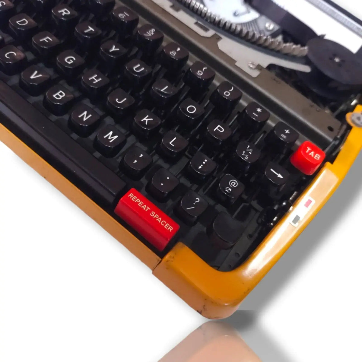 Brother Deluxe 250 TR typewriter close-up showing black English keys, red repeat spacer and yellow factory finish