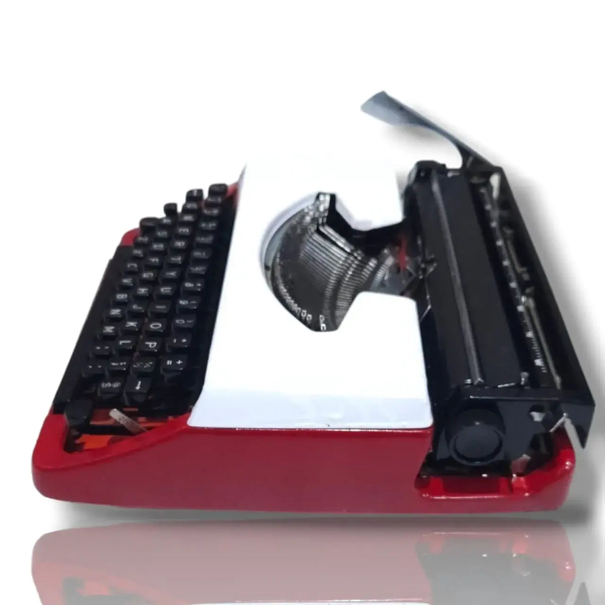 Brother Deluxe 220 portable manual typewriter side view, featuring red and white body, typebars and black carriage