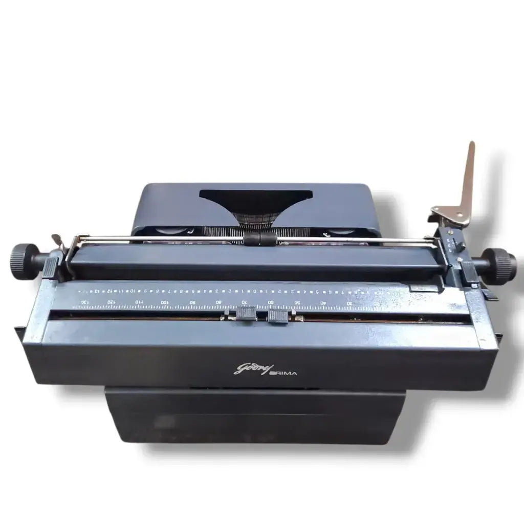 Rear view of Godrej English manual typing machine showing carriage scale, paper guide and mechanical precision