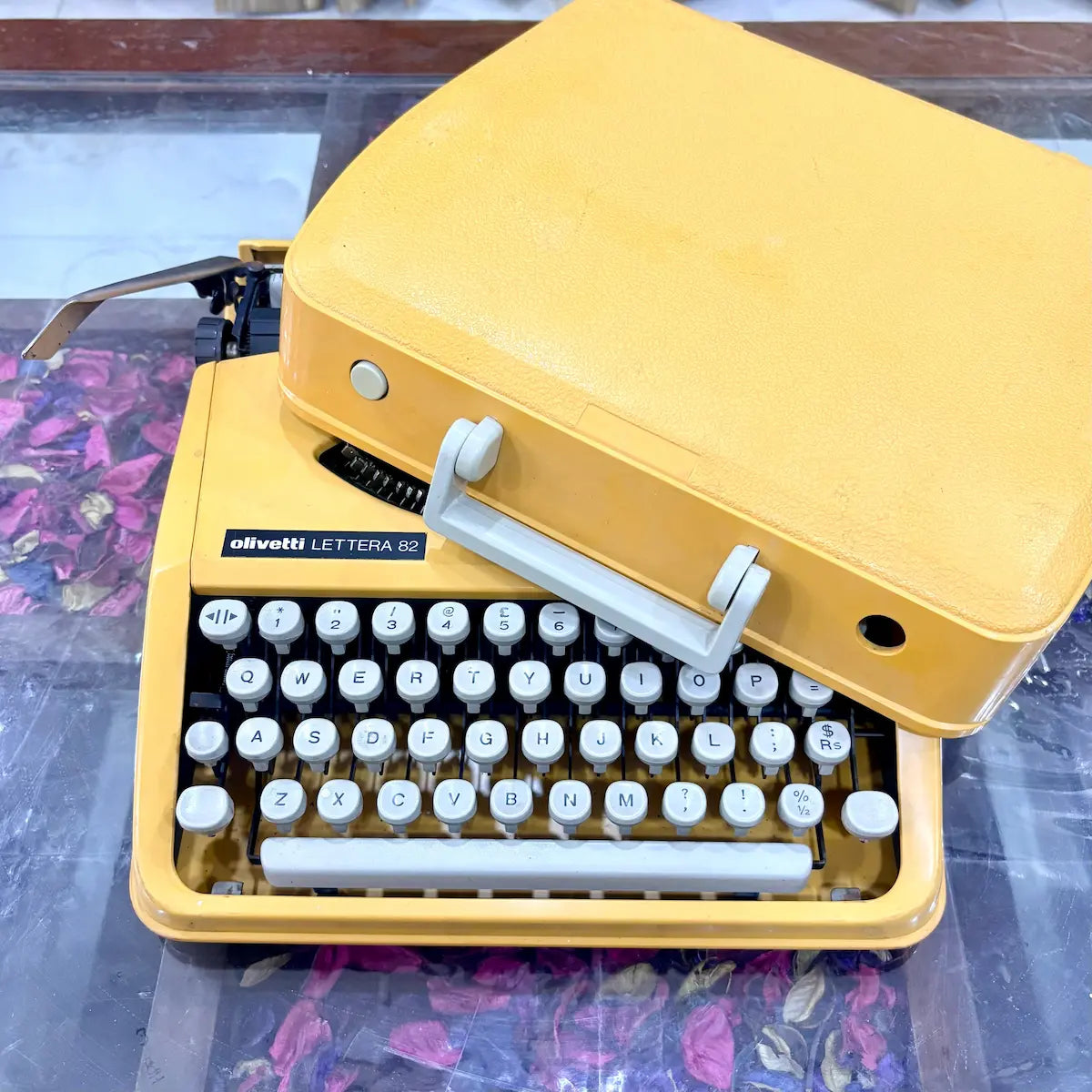 Olivetti Lettera 82 yellow portable typewriter from above, showing white keys and body at RR Typewriter Mart