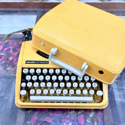 Olivetti Lettera 82 yellow portable typewriter from above, showing white keys and body at RR Typewriter Mart