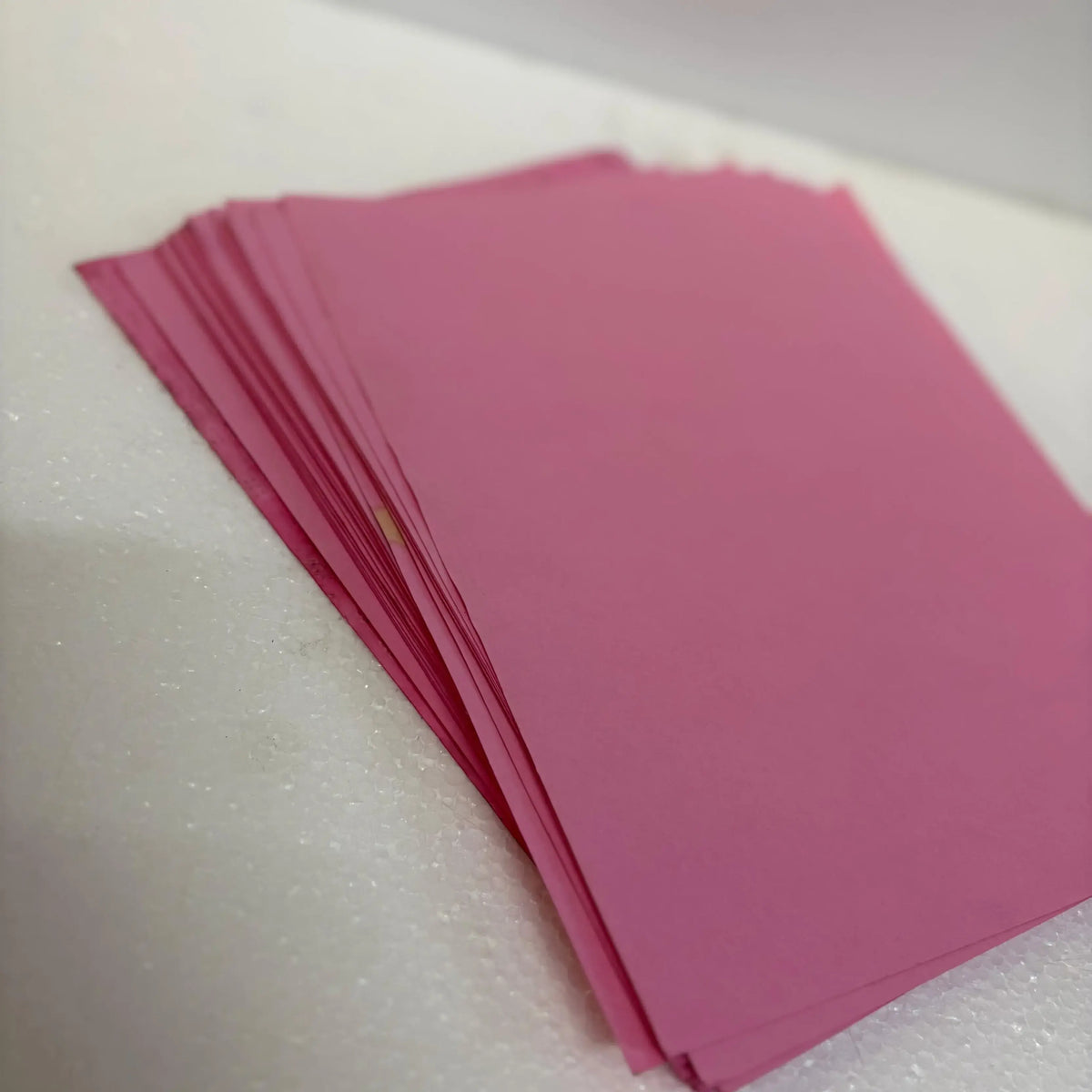 Stack of pink Braille paper for Braille typing machines, available from RR Typewriter Mart for daily use