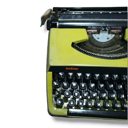 Close-up of olive green Brother Deluxe 220 typewriter showing carriage, typebars and manual English QWERTY keyboard