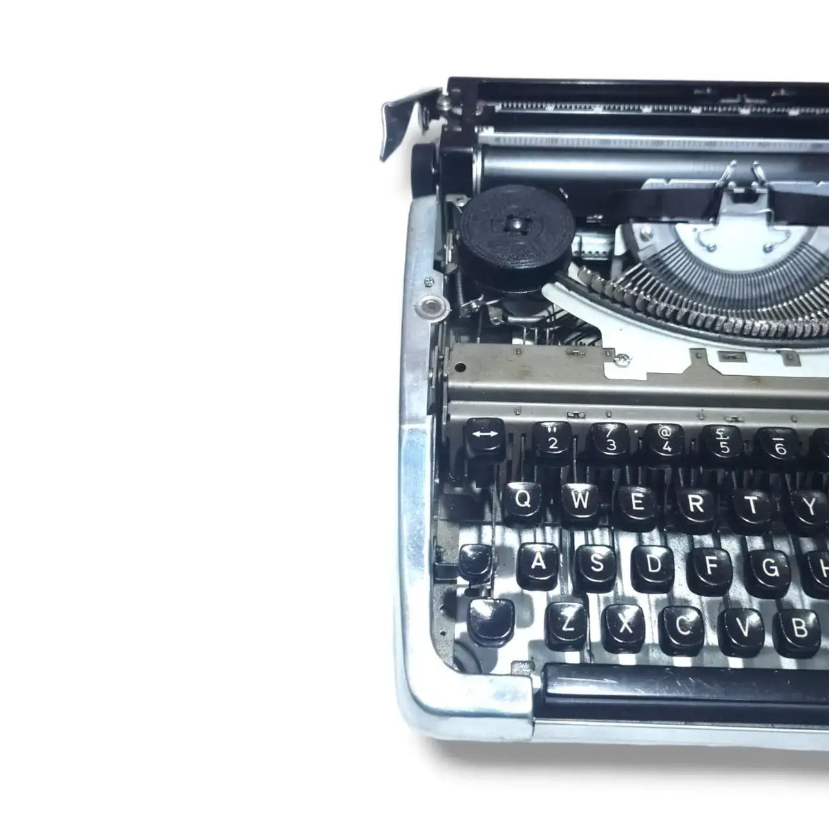 Close-up of Brother 100 chrome typewriter with ribbon spool, English manual typing machine showing internal mechanism