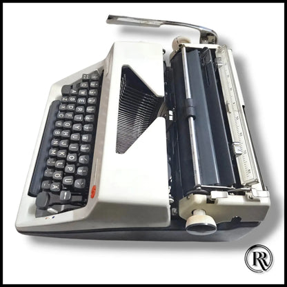 Side view of Olympia Monica vintage typewriter showing carriage, platen and keyboard on German manual typing machine