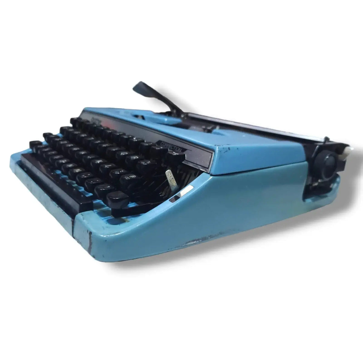 Low side view of blue Brother Charger 11 typewriter, portable English manual typing machine with correction feature