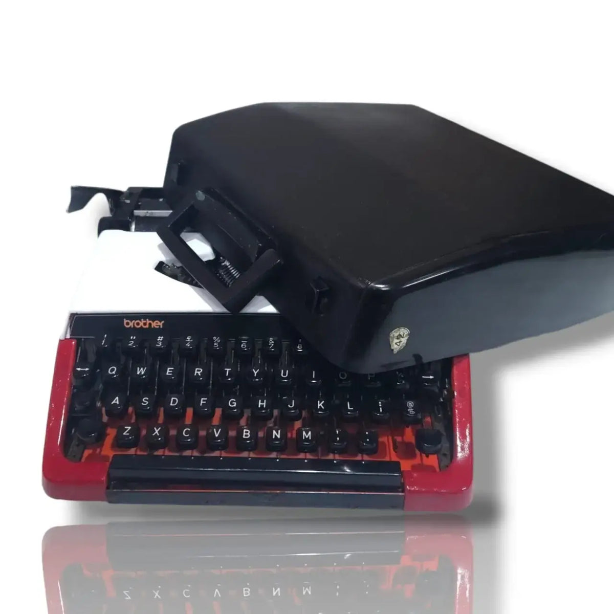 Brother Deluxe 220 Swiss vintage typewriter with black carry case, red and white body and classic QWERTY keyboard