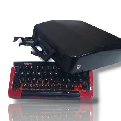 Brother Deluxe 220 Swiss vintage typewriter with black carry case, red and white body and classic QWERTY keyboard