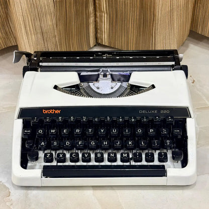 Brother 220 Deluxe Pearl White typewriter showing full keyboard, carriage and compact body, a classic portable machine for writers