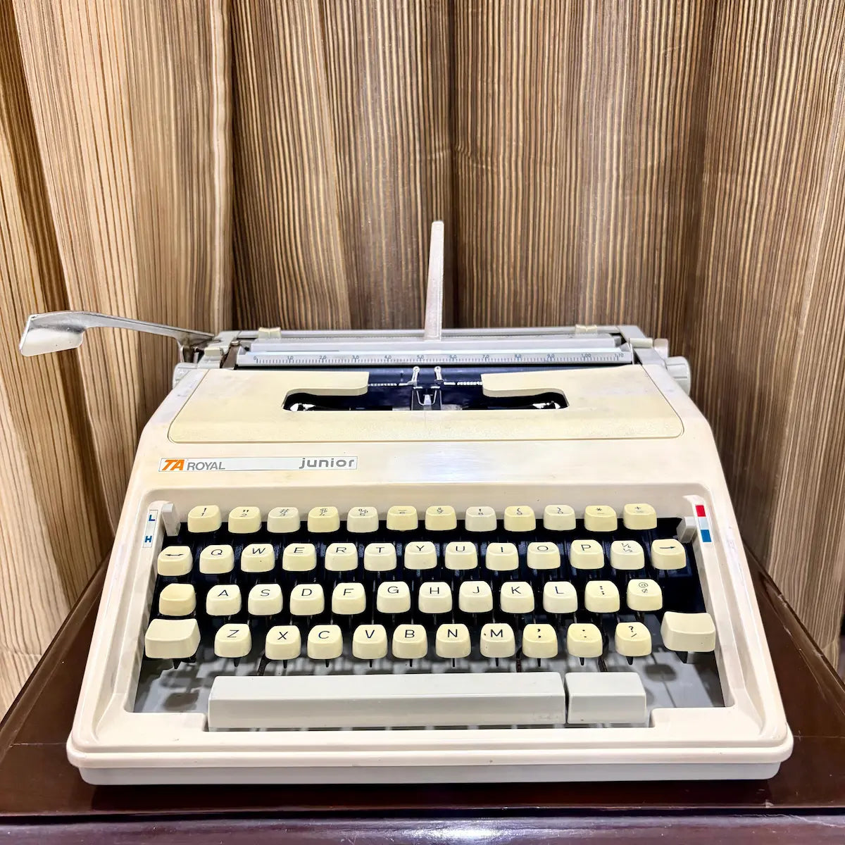 Royal Junior portable typewriter upright in hard case, showing cream body and compact design, from RR Typewriter Mart.