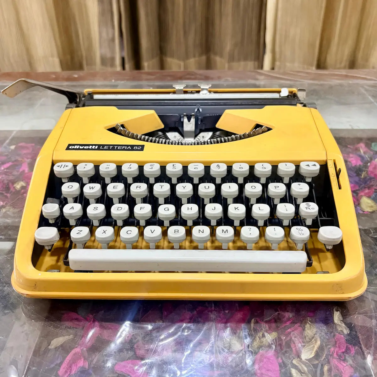 Yellow Olivetti Lettera 82 vintage typewriter from the front, showing white keys and black mechanism at RR Typewriter Mart
