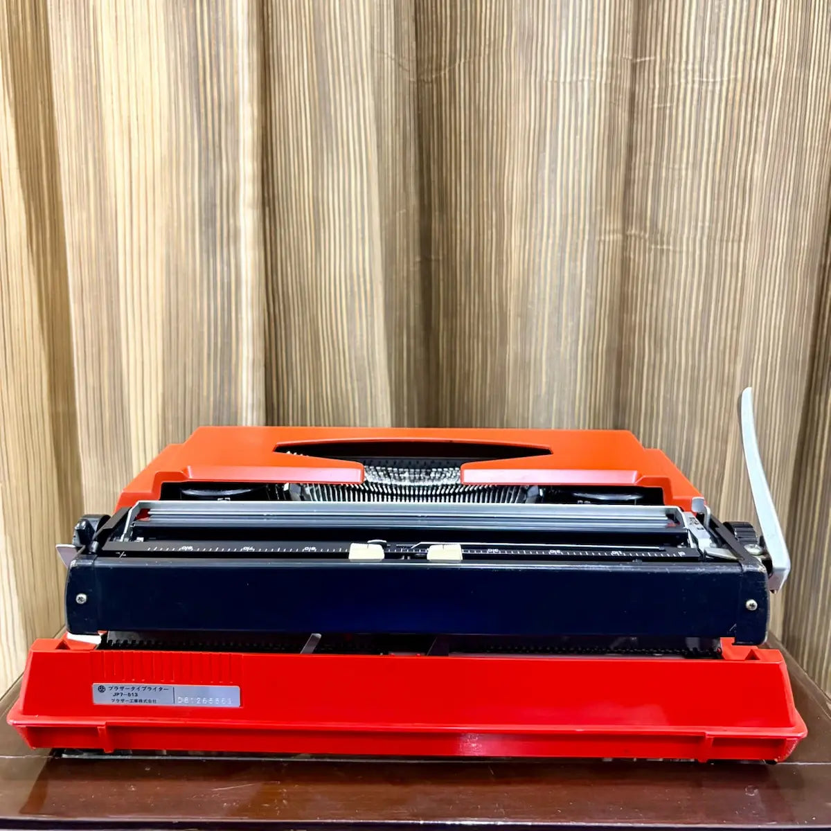 Brother Young Elite 513 portable typewriter, close-up of platen knobs and carriage controls on a scarlet red manual machine | RR Typewriter Mart
