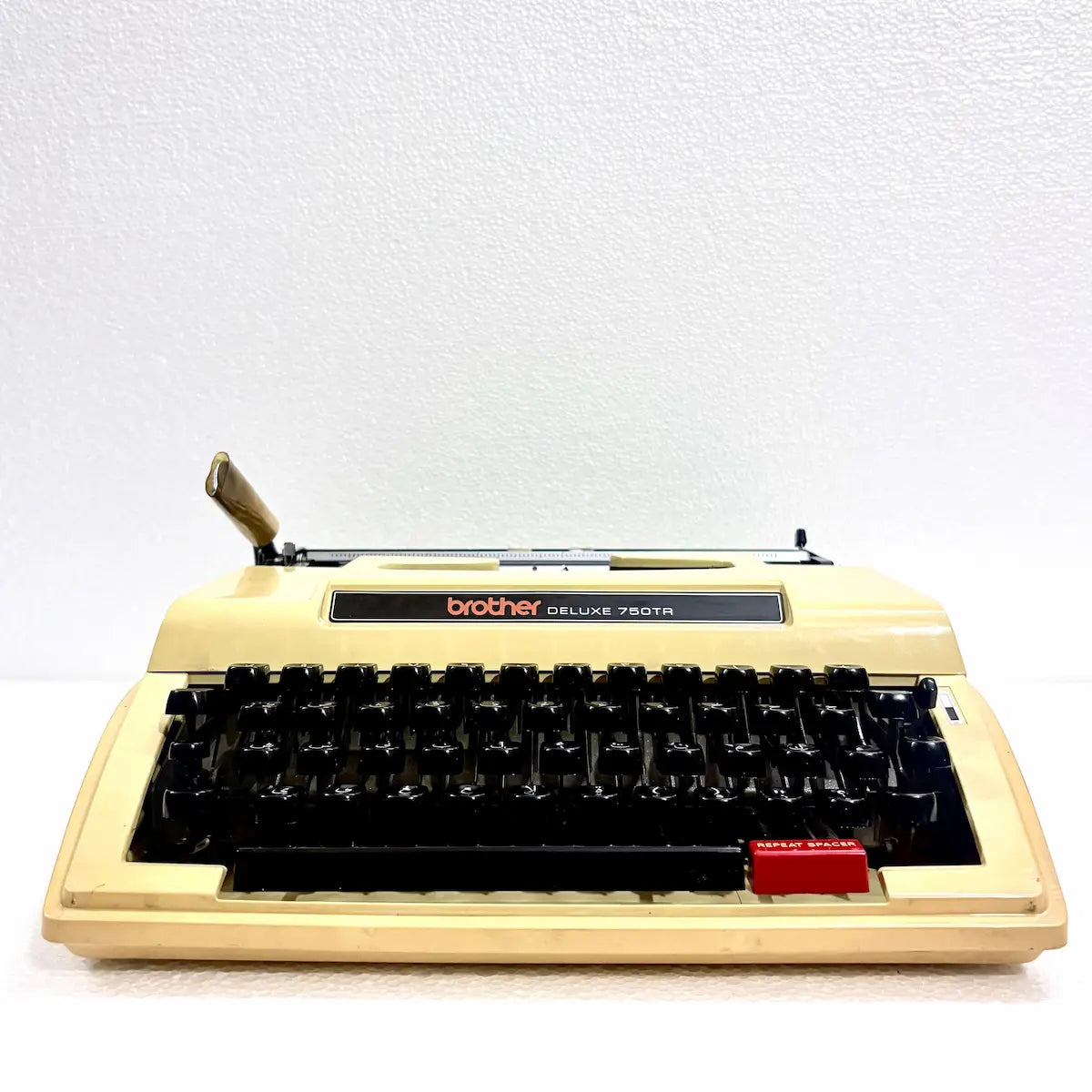 Brother Deluxe 750TR Arabic typewriter close view showing Arabic characters, black keyboard and cream vintage body, ready for writing