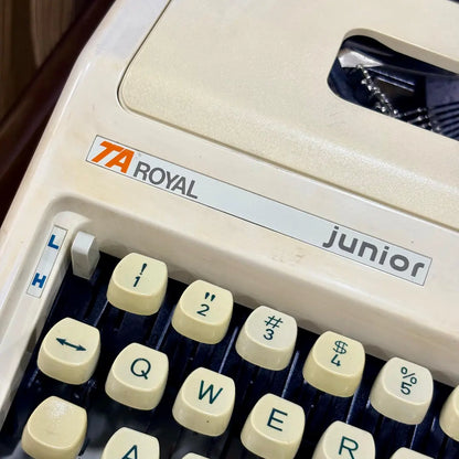 Royal Junior typewriter close-up showing Royal branding, cream body and mechanical keys, from RR Typewriter Mart.
