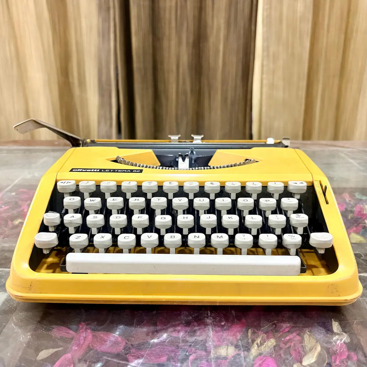 Front angled view of Brazilian Olivetti Lettera 82 portable manual typewriter in yellow, RR Typewriter Mart