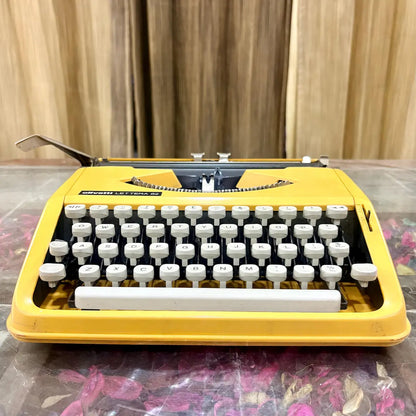 Front angled view of Brazilian Olivetti Lettera 82 portable manual typewriter in yellow, RR Typewriter Mart