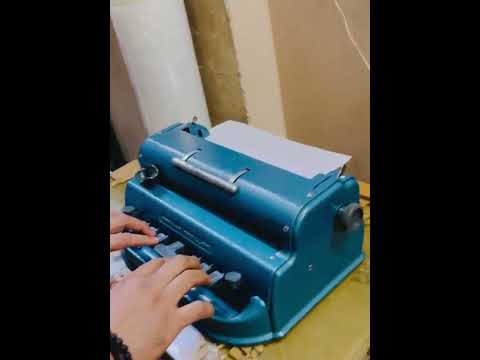 Blue Perkins Braille Typewriter being used for Braille typing, showcasing a manual Braille typing machine at RR Typewriter Mart